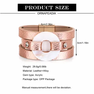 Primer plano de pulsera ancha de cuero oro rosa con aro de acrílico blanco y cristales finos