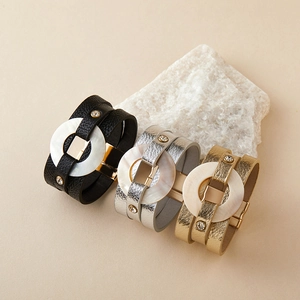 Detalle de pulseras multicapa de cuero PU con inserto de nácar y detalles de cristal