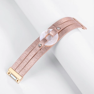 Detalle de pulsera multicapa de cuero sintético oro rosa con nácar y cierre magnético