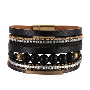 Dettaglio del bracciale multistrato bohémien in pelle nera con chiusura magnetica oro