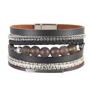 Dettaglio di bracciale multistrato boho con perle di cristallo e chiusura magnetica