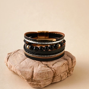 Dettaglio del bracciale bohémien multistrato in pelle nera con strass e chiusura magnetica