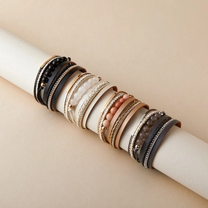 Dettaglio di quattro set di braccialetti bohémien a più strati in pelle PU e perle