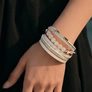 Bracciale bohémien multistrato con cristalli rosa e pelle color crema sul polso