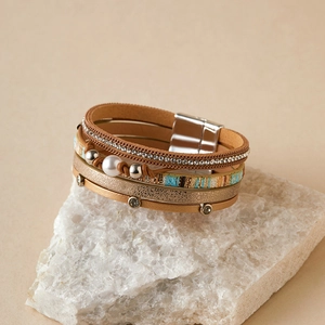 Détail du bracelet bohème en cuir avec des strass blancs et une perle d'eau douce
