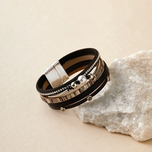 Détail du bracelet multicouche en cuir avec perle, strass et fermoir magnétique