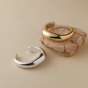 Gepolijste acryl open armbanden in goud en zilver met een minimalistisch druppelontwerp