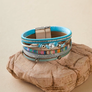 Détail d'un bracelet bohème multicouche en cuir avec cristaux et fermoir aimanté