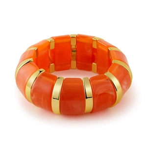 Gros plan d'un bracelet bohème en résine marbrée orange avec des perles en métal doré