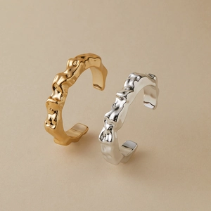 Detail van bohemien open ringen met onregelmatige lavatextuur in goud en zilver finish