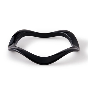 Détail macro du bracelet en acrylique noir brillant avec design à vagues irrégulières