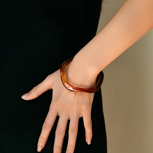 Bracelet en résine marron ambre translucide avec un design minimaliste à vagues larges
