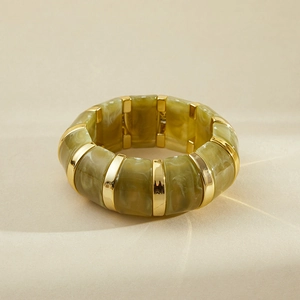 Gros plan du bracelet élastique en résine marbrée verte et entretoises dorées