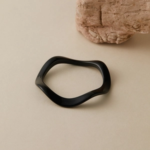 Vue détaillée du bracelet à vagues en acrylique noir brillant au design moderne