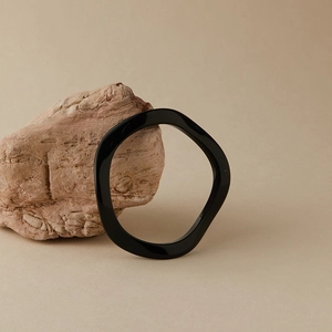 Détail du bracelet jon jonc noir irrégulier en acrylique avec une finition d'art moderne