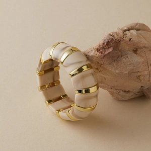 Gros plan d'un bracelet vintage en acrylique marbré avec d'élégants segments dorés