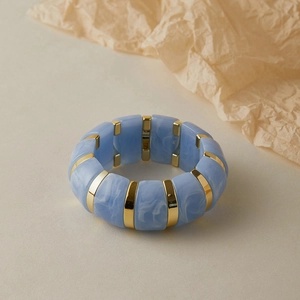 Détail de bracelet avec carreaux en acrylique marbre bleu clair et séparateurs dorés polis