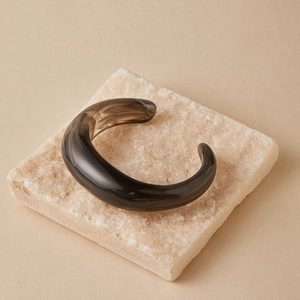 Dettaglio del bracciale rigido aperto in resina grigio fumo traslucido con finitura lucida