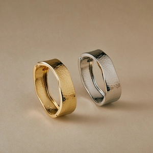 Minimalist wide cuff bracelets in gold and silver with textured hammered surface and hinge