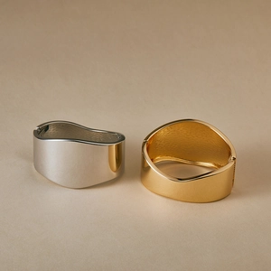 Polished wide wave cuff bracelet in gold and silver finish with mirrored metal texture