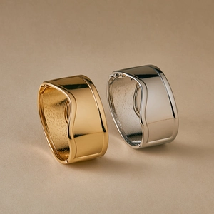 Polished gold and silver irregular wave cuff bracelets with a modern metallic mirror finish