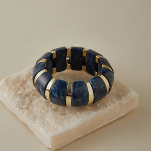 Détail d'un bracelet vintage en résine marbrée bleue avec séparateurs en métal doré