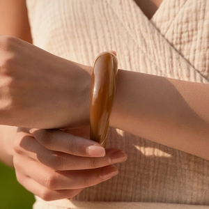 Bracciale rigido in acrilico ambra con finitura in resina lucida per un look retrò minimalista