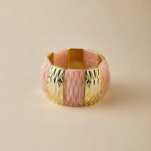 Bracelet manchette large en résine rose marbrée et accents métalliques dorés géométriques