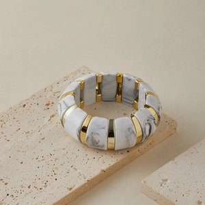 Gros plan du bracelet élastique rétro en acrylique avec texture marbre et détails dorés