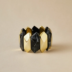 Detalle de brazalete geométrico con bloques hexagonales dorados e incrustaciones de resina