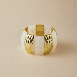 Close-up of elastic bangle featuring gold diamond-textured metal and marble resin panels