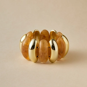 Macro detail of elastic beaded bracelet with gold metal and amber resin flat oval tubes