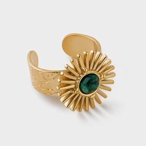 Detailed macro view of retro 18K gold plated ring with green stone and sunburst pattern