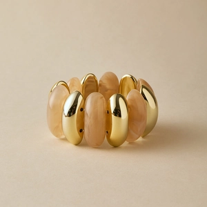Close-up of gold metal sections and marble resin beads on a stretch tube bracelet