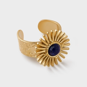 Detail of vintage gold ring with blue stone inlay and hand-hammered sunburst texture