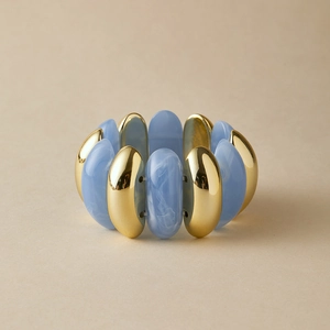 Wide elastic bracelet with alternate gold metal and blue marbled acrylic resin blocks