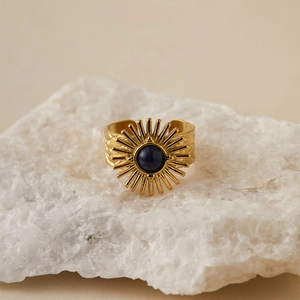 Macro shot of gold sunburst ring with blue lapis stone on white crystal cluster base