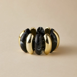 Detail of bohemian stretch bracelet with golden metal and marble resin oval beads