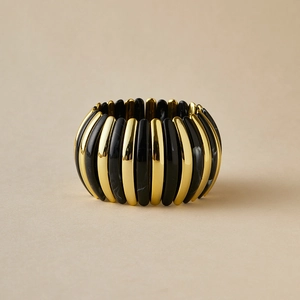 Detail of bohemian acrylic bangle with marbled black and gold stretch cord design