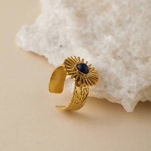 Detail of vintage gold ring with radial sunburst design and lapis lazuli stone inlay