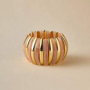 Gros plan du bracelet large élastique en résine marbrée rose et barres dorées polies