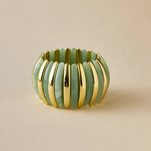 Detail of bohemian stretch bracelet with marbled green resin and gold polished metal segments