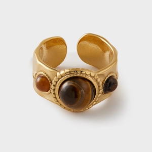 Macro view of vintage gold ring with tiger eye stone and intricate hammered metal texture
