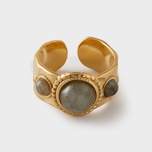 Detailed macro view of vintage gold ring with three grey gemstones and hammered texture