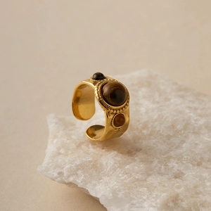 Detail of vintage gold ring with hammered texture and three brown tiger eye stones