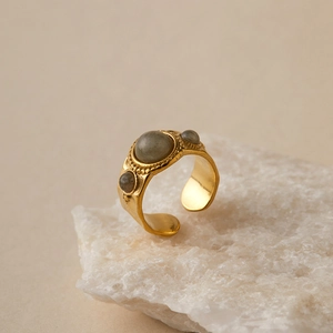 Detailed close-up of a gold boho ring with grey-blue stones on white mineral crystals