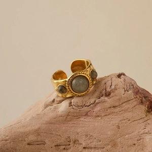 Detail of vintage gold-plated wide ring set with three translucent grey stones on stone