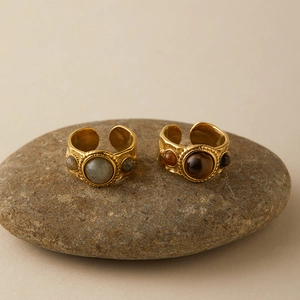 Vintage gold adjustable rings set with labradorite and tiger eye stones on raw rock