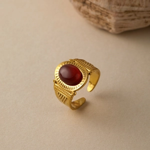 Detail of vintage gold ring with oval reddish stone and textured bohemian patterns