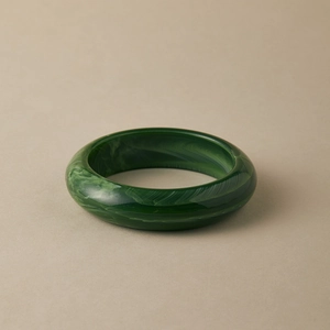 Detail of dark green acrylic bangle with marbled textures and a vintage round design